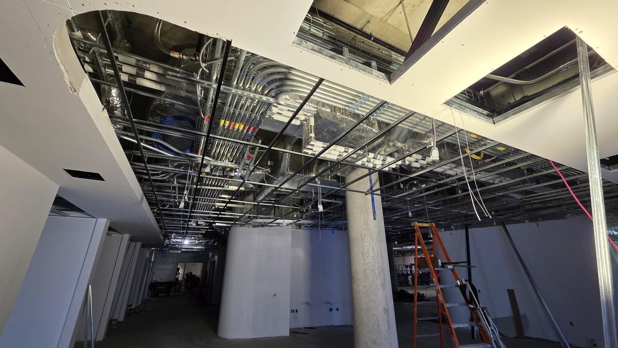 A wide view locates the T-bar grid, surrounding room edges and overhead services.