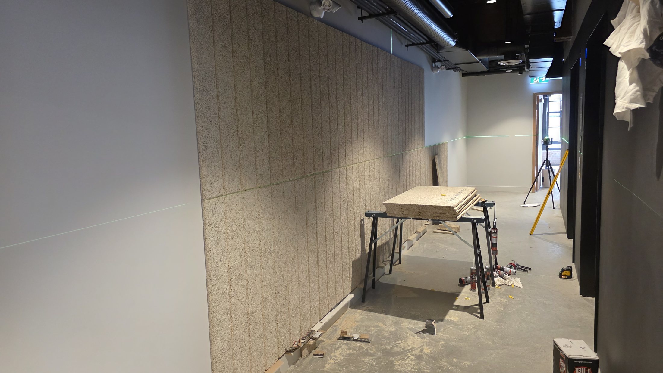Rambo Walls and Ceilings installing vertical acoustic wall panels in the Vancouver lobby